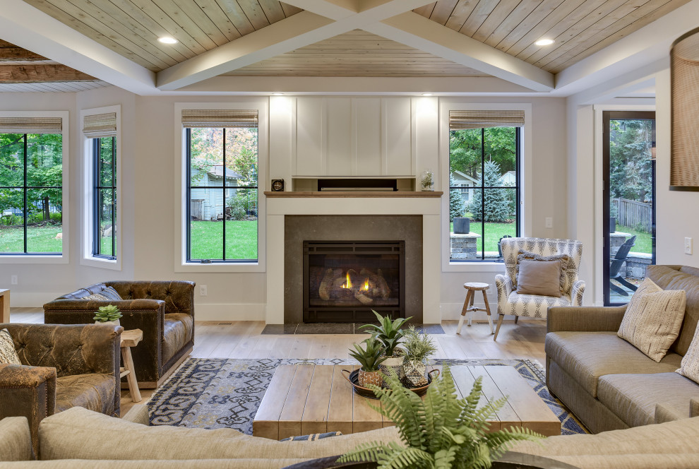 Idée de décoration pour un salon champêtre de taille moyenne et ouvert avec un mur blanc, un sol en bois brun, une cheminée standard, un manteau de cheminée en béton, un téléviseur dissimulé et un sol marron.