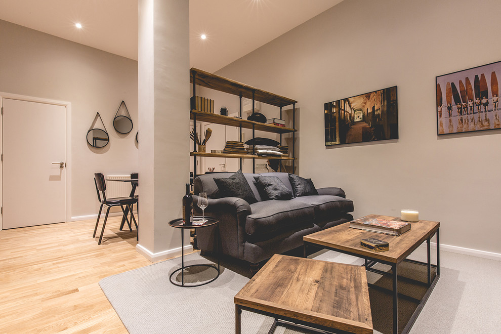 Mittelgroßes Industrial Wohnzimmer mit grauer Wandfarbe und hellem Holzboden in London