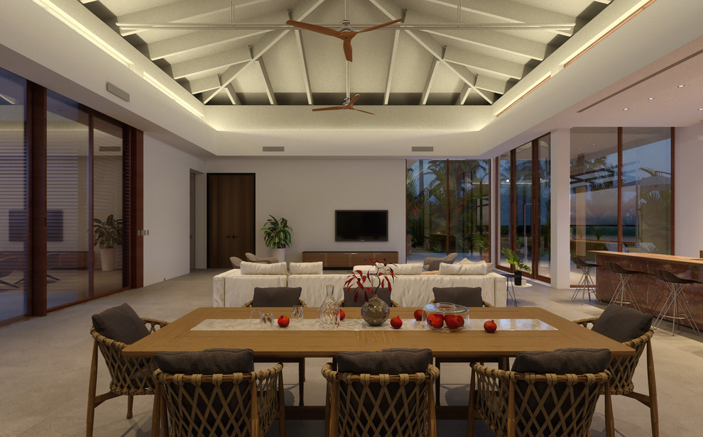 Immagine di un soggiorno tropicale di medie dimensioni e stile loft con angolo bar, pareti bianche, pavimento in pietra calcarea, TV nascosta e pavimento grigio
