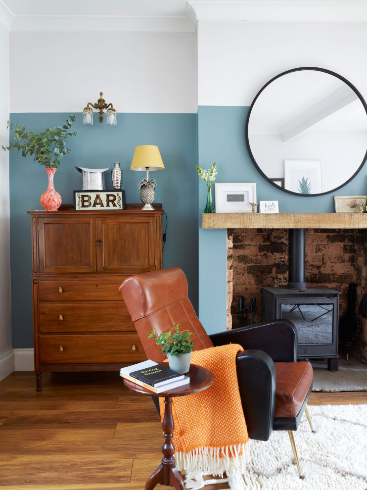 Foto di un soggiorno boho chic di medie dimensioni con angolo bar, pareti blu, pavimento in legno massello medio, stufa a legna e pavimento marrone