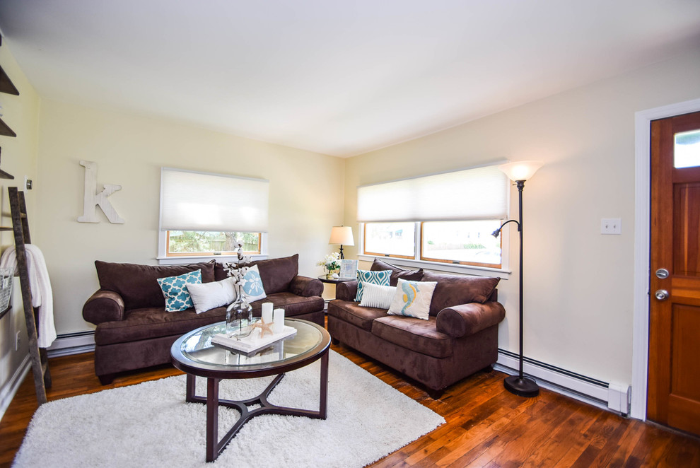 Kleines Landhausstil Wohnzimmer mit beiger Wandfarbe, hellem Holzboden und braunem Boden in Philadelphia