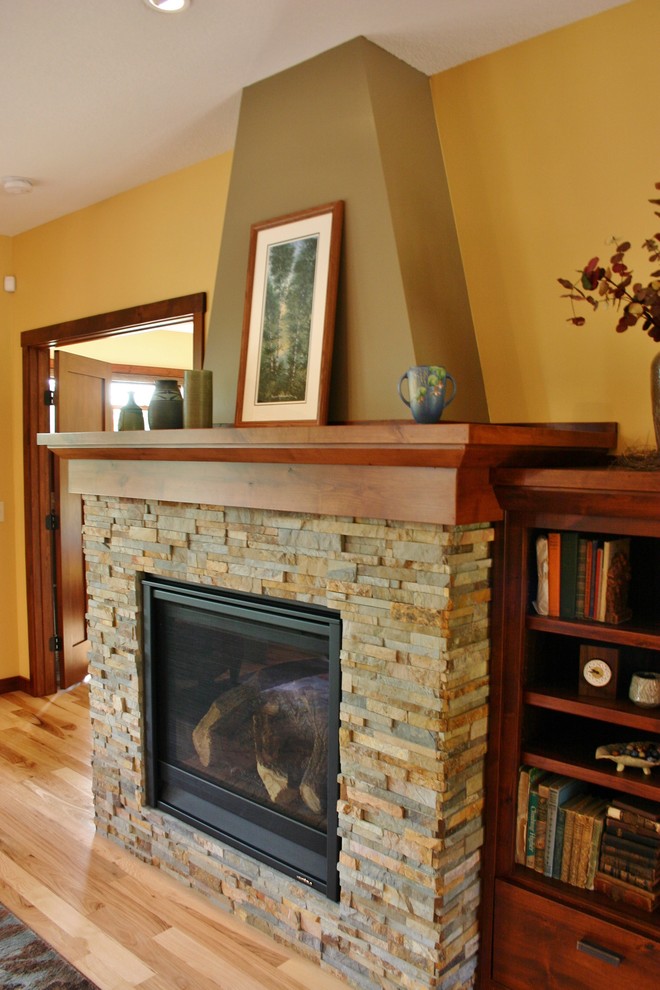 ミネアポリスにある高級な中くらいなトラディショナルスタイルのおしゃれなLDK (淡色無垢フローリング、標準型暖炉、石材の暖炉まわり) の写真