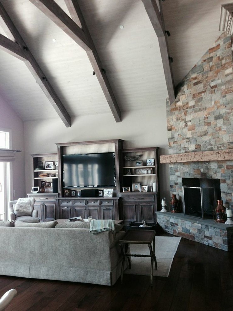 Example of a large mountain style open concept medium tone wood floor living room design in San Francisco with a music area, beige walls, a corner fireplace, a stone fireplace and a tv stand