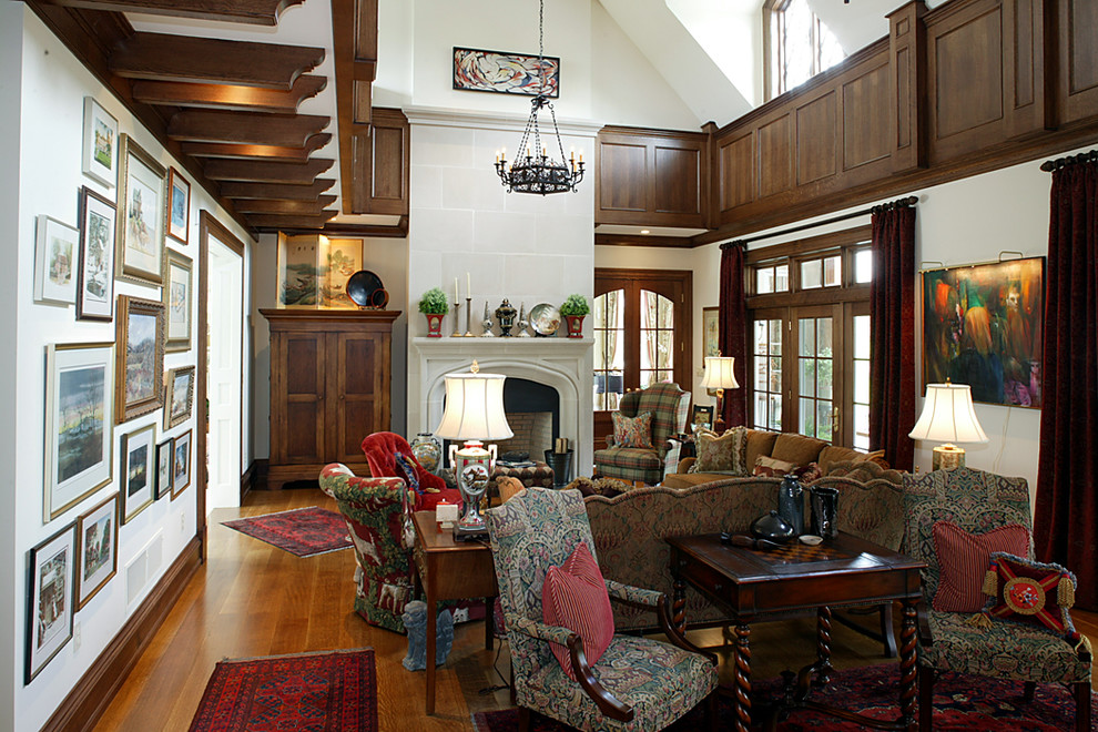 Cette photo montre un grand salon chic fermé avec une salle de réception, un mur blanc, un sol en bois brun, une cheminée standard, un manteau de cheminée en béton et un sol marron.