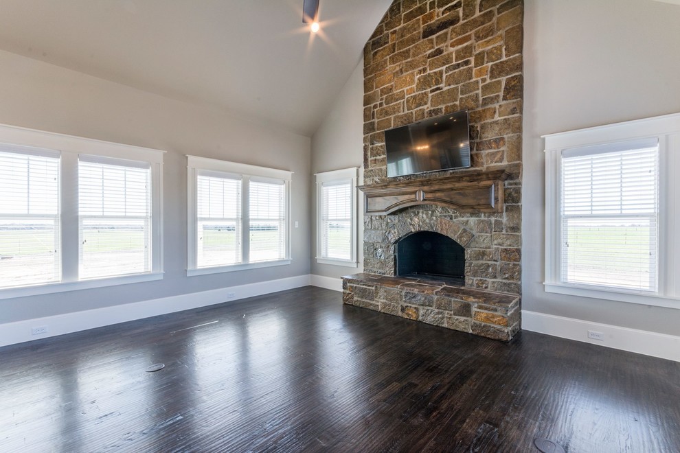 Inspiration for a large country open plan living room in Dallas with grey walls, dark hardwood flooring, a standard fireplace, a stone fireplace surround and no tv.