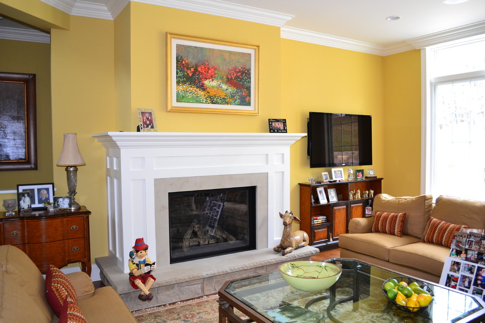На фото: парадная, открытая гостиная комната среднего размера в стиле кантри с желтыми стенами, паркетным полом среднего тона, стандартным камином, фасадом камина из дерева и телевизором на стене с