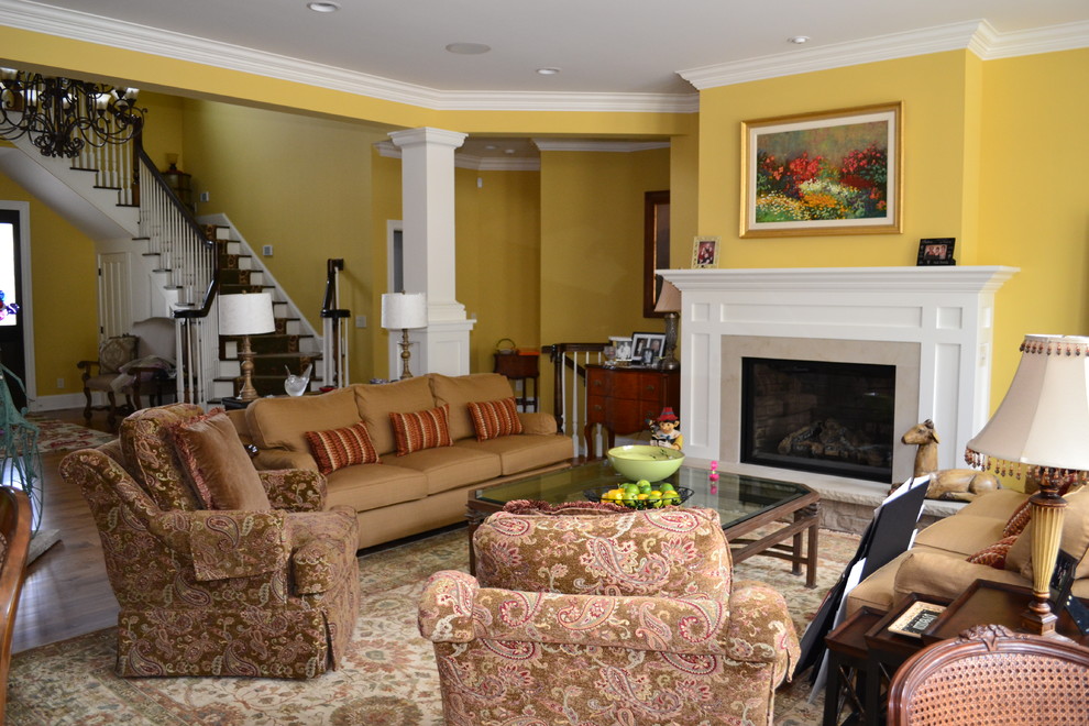 Cette image montre un salon rustique de taille moyenne et ouvert avec une salle de réception, un mur jaune, un sol en bois brun, une cheminée standard et un manteau de cheminée en bois.