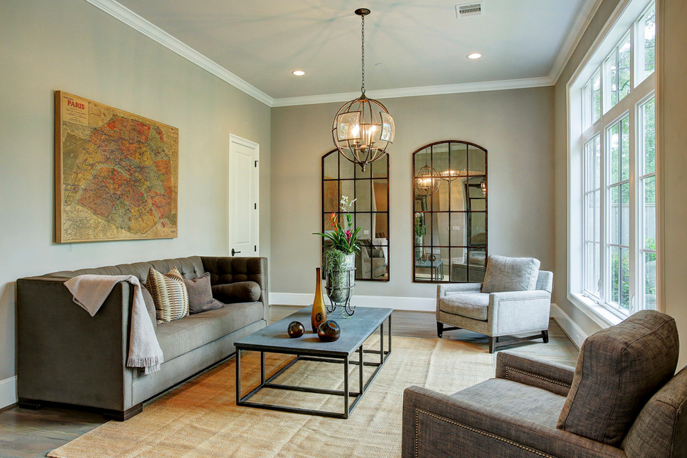 Example of a transitional formal and enclosed medium tone wood floor living room design in Houston with gray walls and a wall-mounted tv