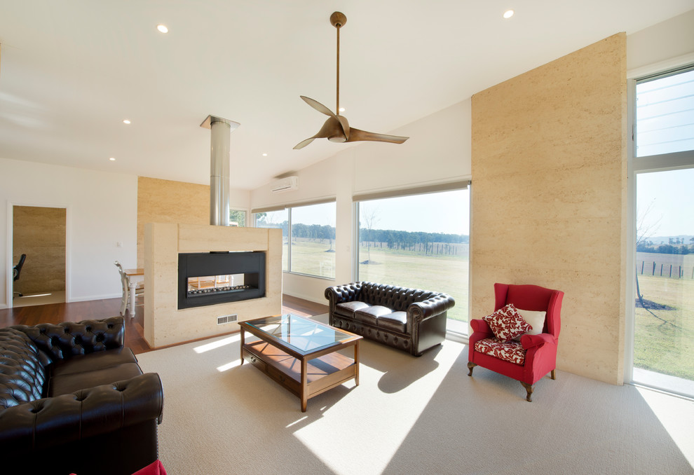 This is an example of a large contemporary open plan living room feature wall in Newcastle - Maitland with white walls, dark hardwood flooring, a two-sided fireplace and a stone fireplace surround.