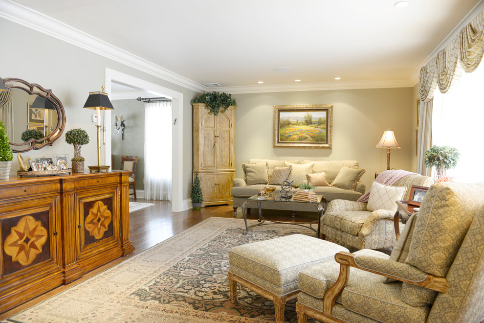 Example of a large classic enclosed medium tone wood floor living room design in New York with beige walls and no tv