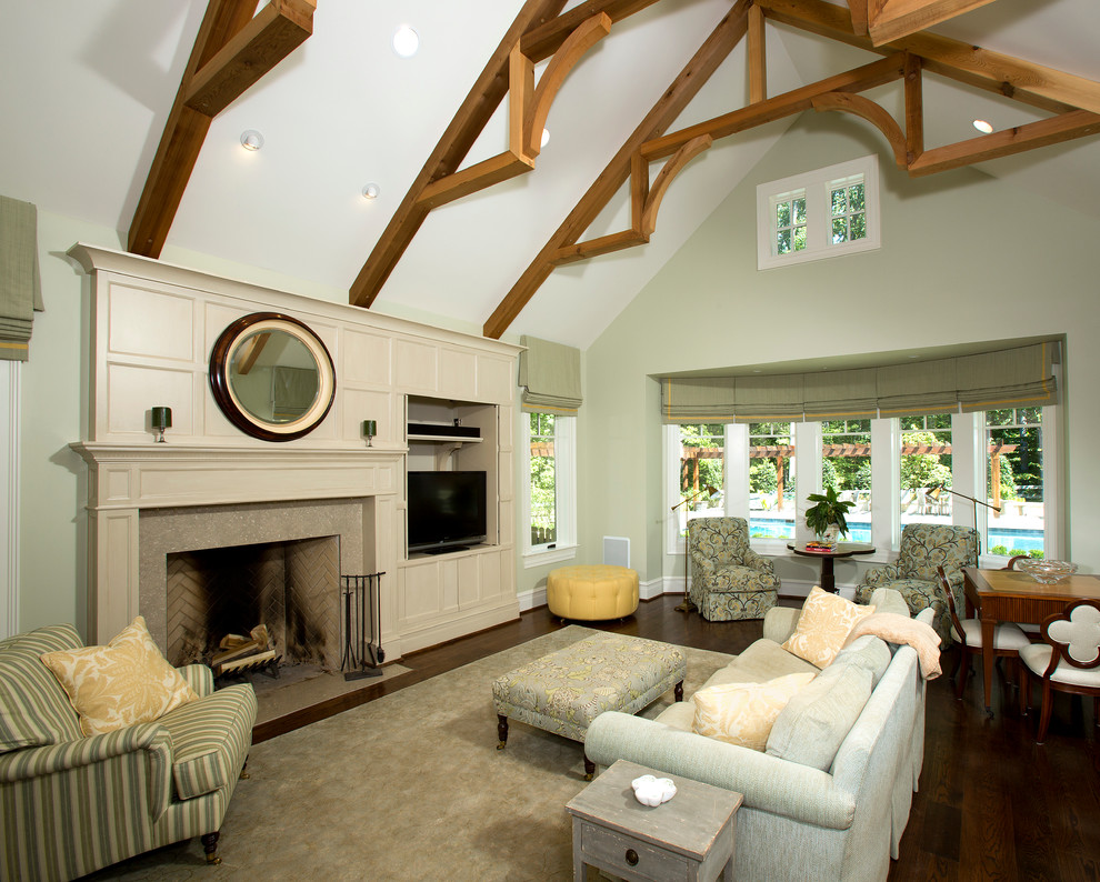 На фото: огромная гостиная комната в классическом стиле с зелеными стенами и стандартным камином с