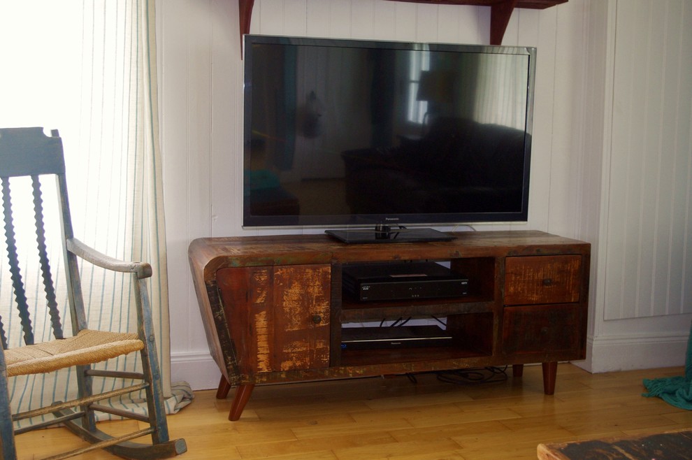Rustik inredning av ett vardagsrum, med ljust trägolv och en fristående TV
