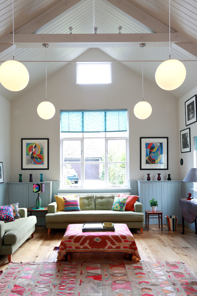 This is an example of a scandi open plan living room in London with white walls and light hardwood flooring.