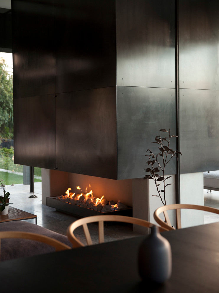 Foto di un soggiorno minimalista di medie dimensioni e aperto con sala formale, pareti grigie, pavimento in ardesia, camino classico e cornice del camino in metallo