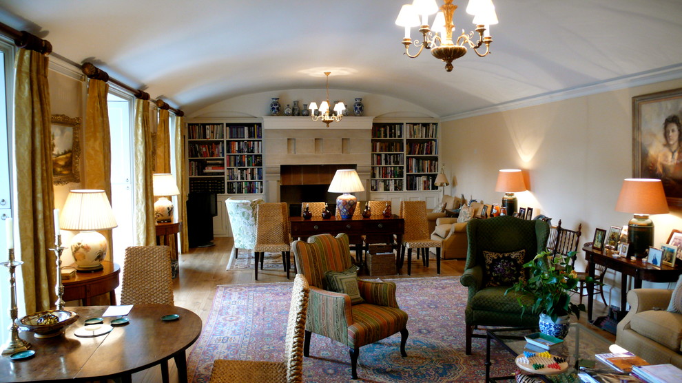 Foto på ett stort vintage separat vardagsrum, med ett bibliotek, beige väggar, heltäckningsmatta, en standard öppen spis och en spiselkrans i sten