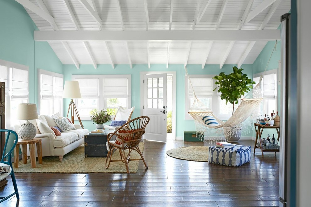Small coastal open plan living room in New York with green walls, medium hardwood flooring, brown floors and feature lighting.