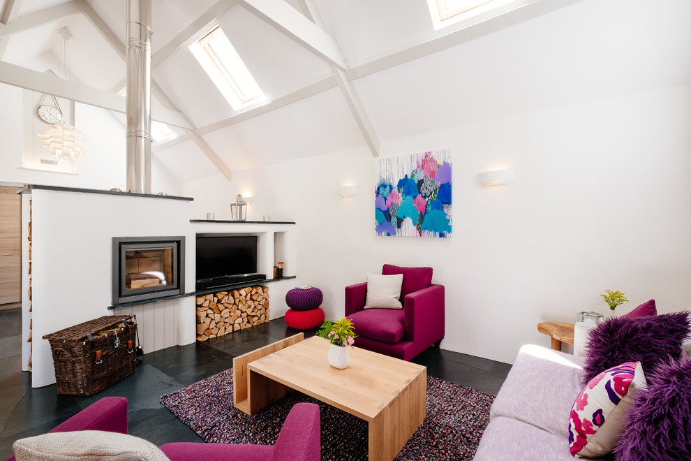 Offenes Landhaus Wohnzimmer mit weißer Wandfarbe, Kamin und schwarzem Boden in Cornwall