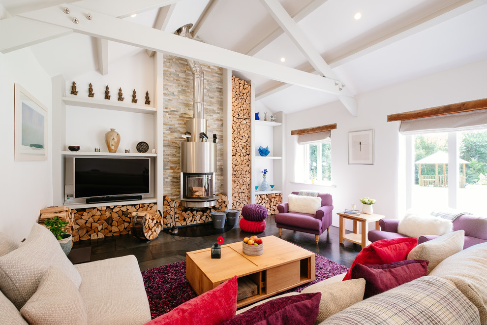Offenes Country Wohnzimmer mit weißer Wandfarbe, Kaminofen, TV-Wand und schwarzem Boden in Cornwall