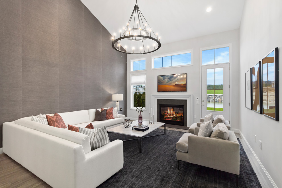 Design ideas for a large contemporary open plan living room in New York with grey walls, a standard fireplace, a tiled fireplace surround and brown floors.