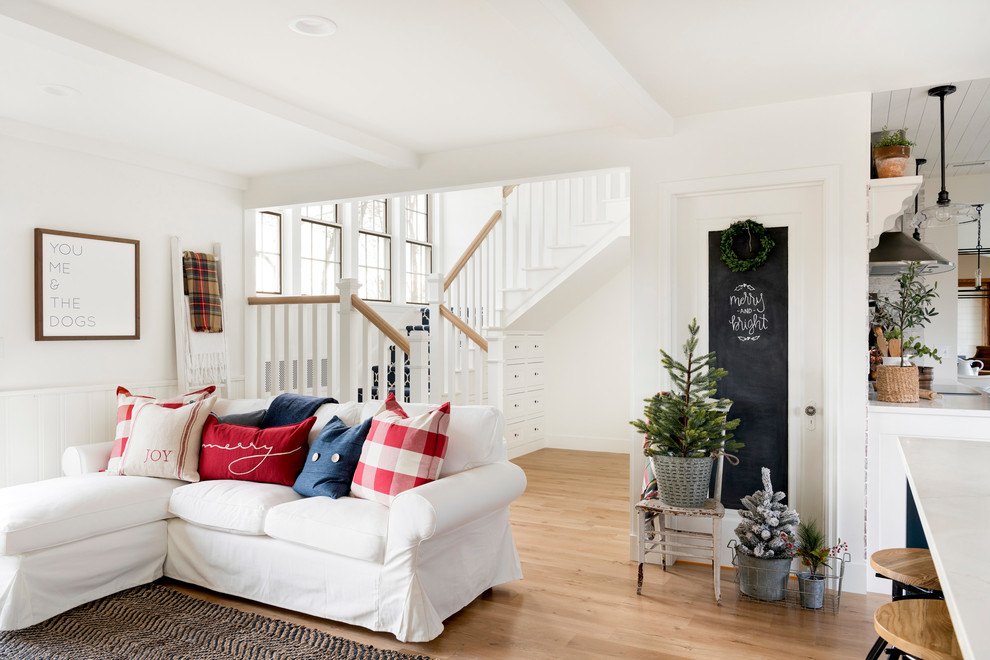 Offenes Landhaus Wohnzimmer mit weißer Wandfarbe, hellem Holzboden, Kamin und Kaminumrandung aus Backstein in Minneapolis