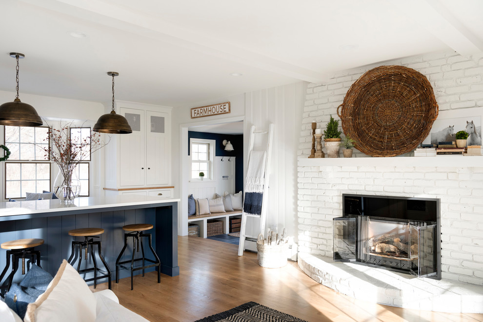 Offenes Landhausstil Wohnzimmer mit weißer Wandfarbe, hellem Holzboden, Kamin und Kaminumrandung aus Backstein in Minneapolis