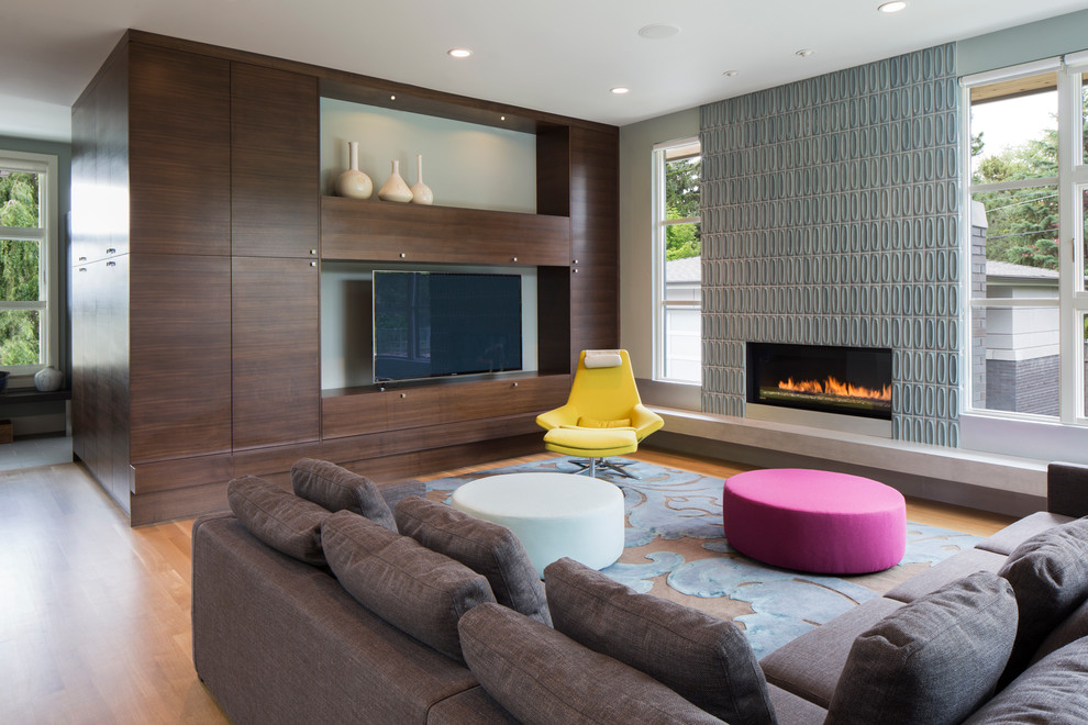 Aménagement d'un salon contemporain de taille moyenne et ouvert avec une salle de réception, un mur bleu, un sol en bois brun, une cheminée ribbon, un manteau de cheminée en carrelage et un téléviseur indépendant.