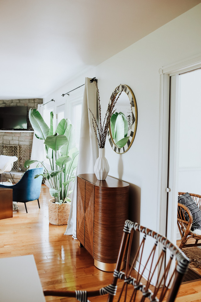 Mittelgroßes, Offenes Modernes Wohnzimmer mit weißer Wandfarbe, braunem Holzboden, Eckkamin, Kaminumrandung aus Backstein und gelbem Boden in Toronto