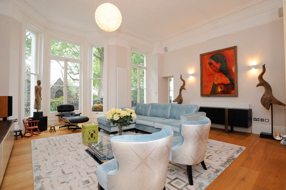 This is an example of a large contemporary formal enclosed living room in London with white walls and medium hardwood flooring.