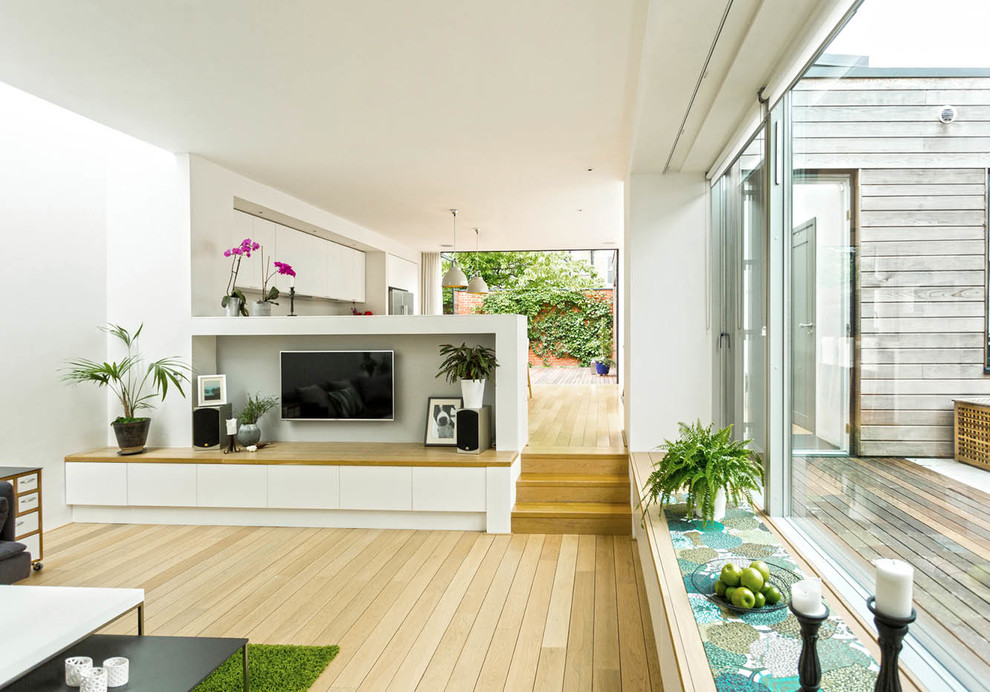 Mittelgroßes, Offenes Modernes Wohnzimmer mit hellem Holzboden und TV-Wand in London