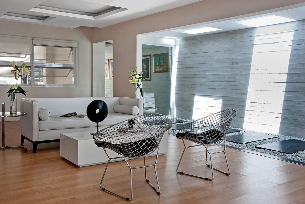 Diseño de salón contemporáneo con paredes beige y suelo de madera en tonos medios