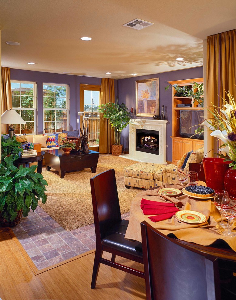 Immagine di un soggiorno aperto con pareti viola, camino classico e TV autoportante