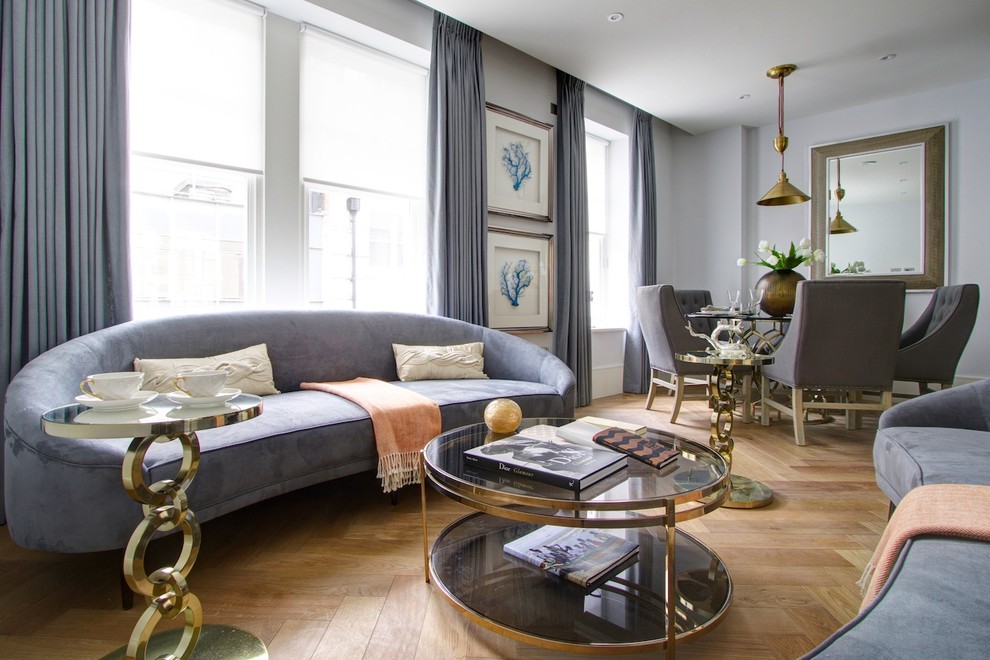 Идея дизайна: открытая гостиная комната в стиле неоклассика (современная классика) с серыми стенами, светлым паркетным полом и красивыми шторами