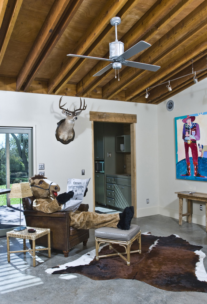 Eklektisches Wohnzimmer mit weißer Wandfarbe und Betonboden in Austin