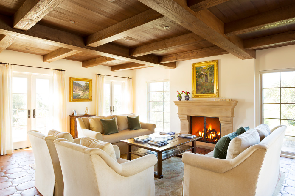 Repräsentatives, Fernseherloses Mediterranes Wohnzimmer mit beiger Wandfarbe, Terrakottaboden, Kamin und verputzter Kaminumrandung in Santa Barbara