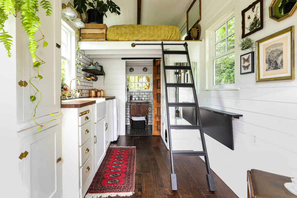 Abgetrenntes Landhausstil Wohnzimmer mit weißer Wandfarbe, dunklem Holzboden und braunem Boden in Portland