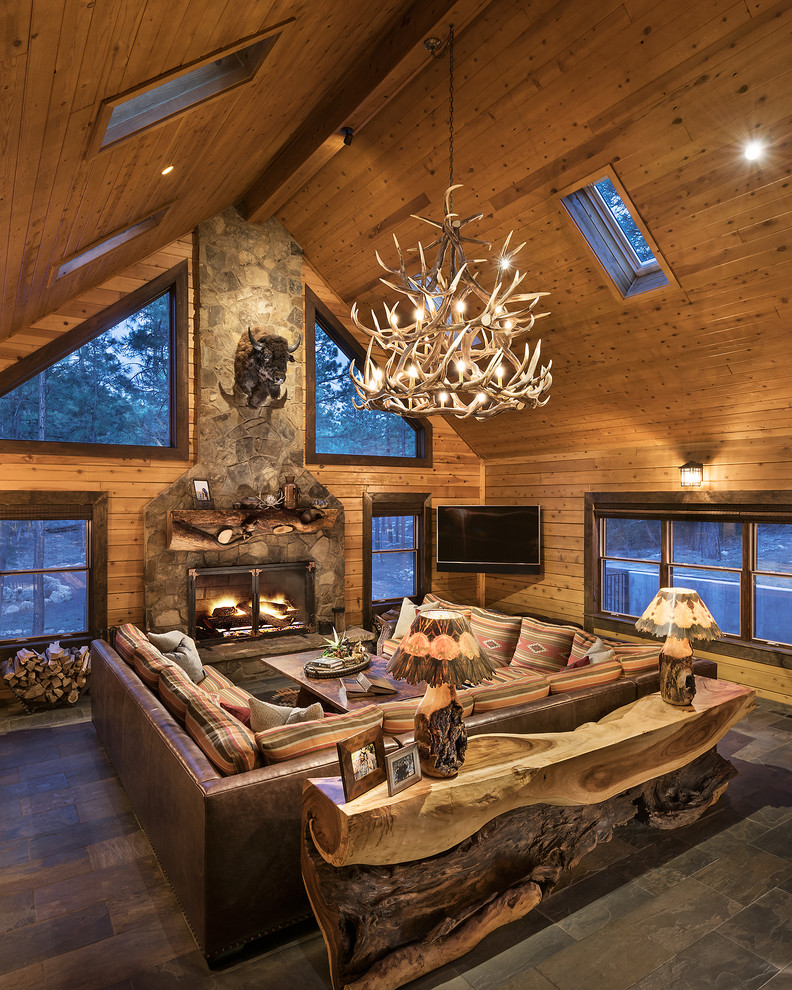 Inspiration for a medium sized rustic open plan living room in Phoenix with brown walls, slate flooring, a standard fireplace, a stone fireplace surround, a wall mounted tv and grey floors.