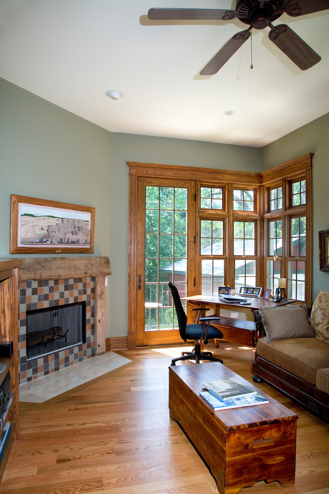 Example of a mid-sized classic enclosed light wood floor living room design in Chicago with green walls, a standard fireplace and a tile fireplace
