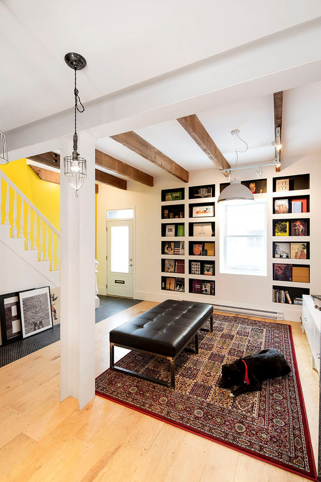Ejemplo de biblioteca en casa abierta campestre pequeña sin chimenea y televisor con paredes amarillas y suelo de madera clara