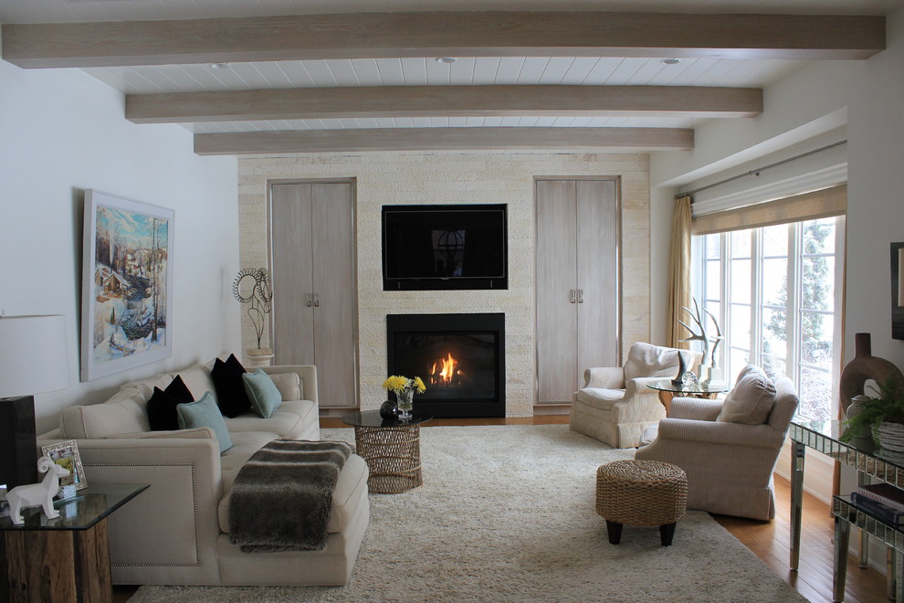 Idée de décoration pour un grand salon design fermé avec un mur blanc, un sol en bois brun, une cheminée standard, un manteau de cheminée en pierre, un téléviseur encastré et un sol marron.