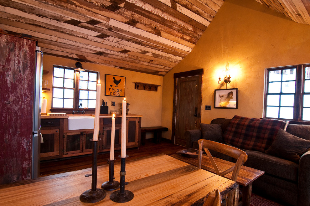 Aménagement d'un petit salon montagne avec un mur jaune et un sol en bois brun.