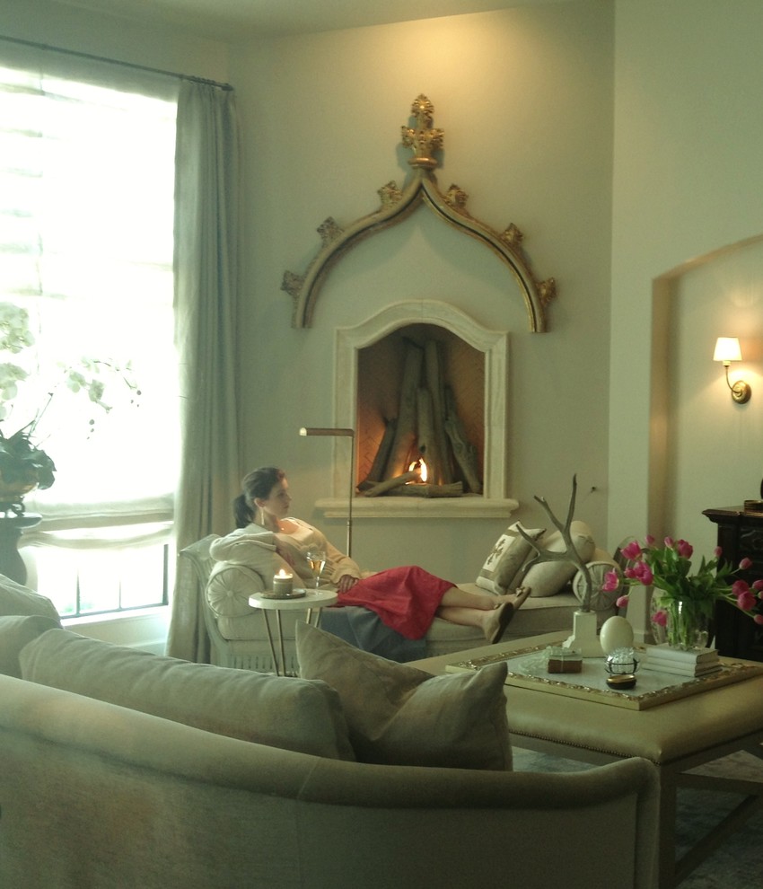 На фото: гостиная комната в стиле неоклассика (современная классика) с угловым камином и фасадом камина из камня