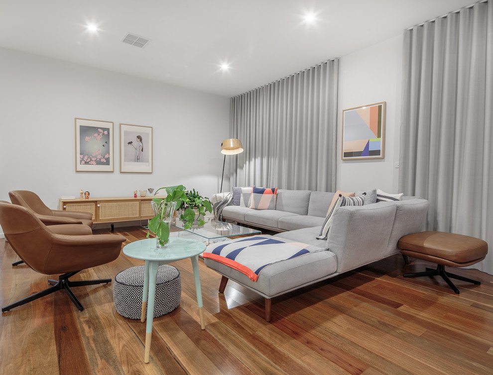 Esempio di un soggiorno minimal con pareti grigie, pavimento in legno massello medio e pavimento marrone