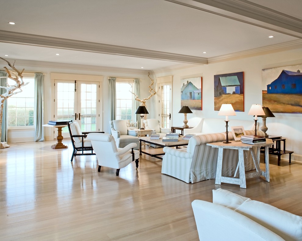 Immagine di un grande soggiorno costiero aperto con sala formale, pareti bianche e parquet chiaro