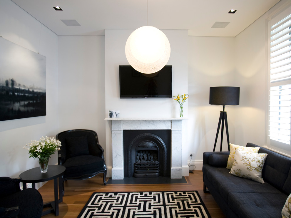 Diseño de salón actual con suelo de madera en tonos medios, todas las chimeneas, televisor colgado en la pared, suelo marrón y alfombra