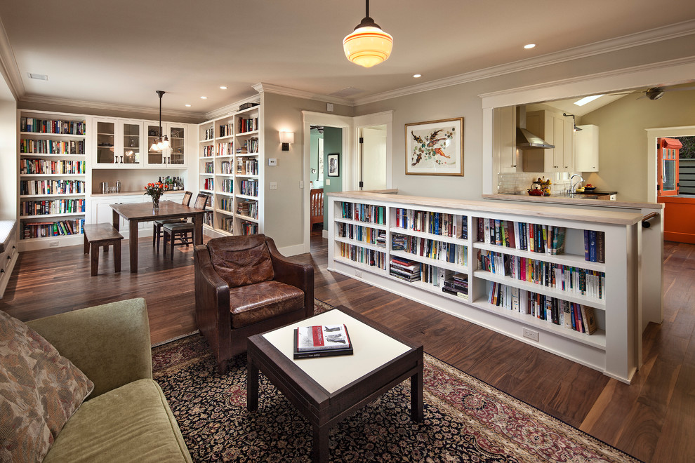 Immagine di un piccolo soggiorno american style aperto con libreria, parquet scuro e nessun camino