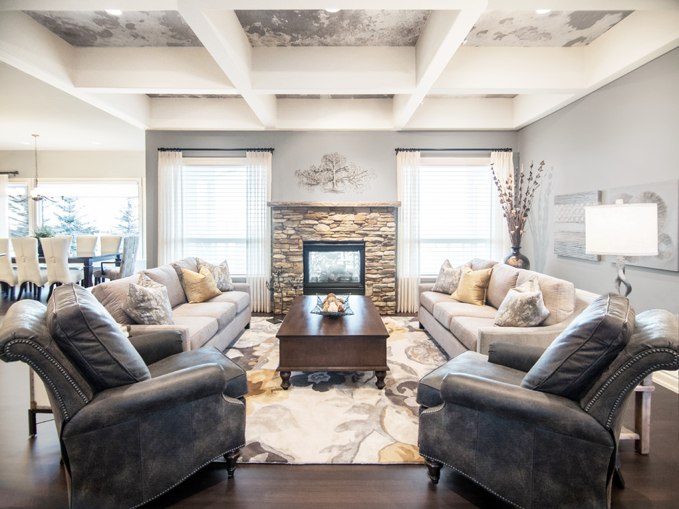 Inspiration for a classic formal open plan living room in Calgary with grey walls, dark hardwood flooring, a two-sided fireplace, a stone fireplace surround, no tv and brown floors.