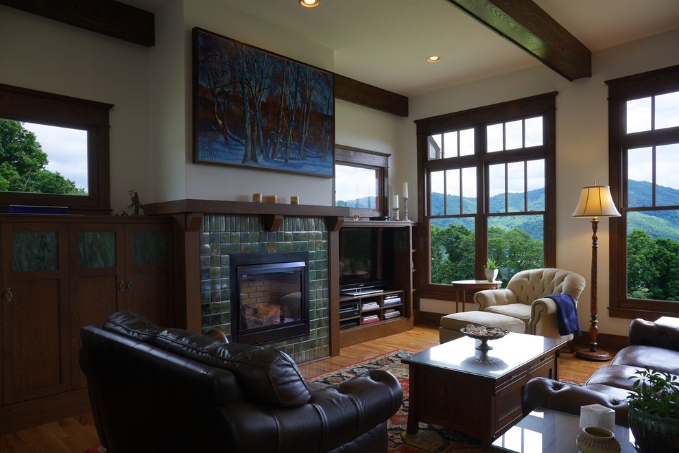 Exemple d'un grand salon craftsman ouvert avec un mur beige, un sol en bois brun, une cheminée standard et un manteau de cheminée en carrelage.