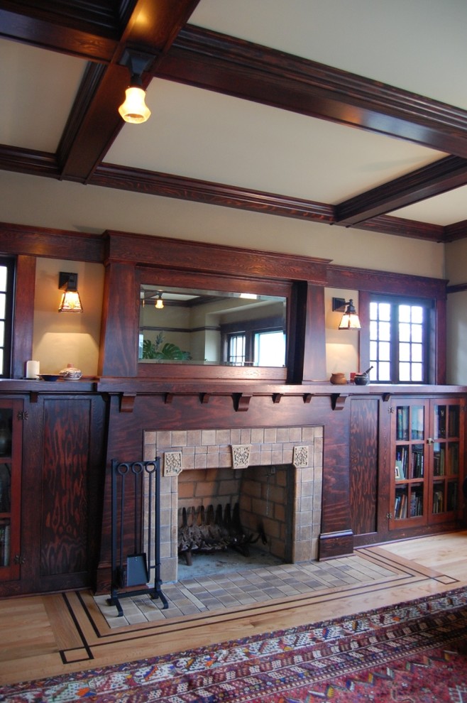 Foto de biblioteca en casa cerrada de estilo americano de tamaño medio con paredes beige, suelo de madera clara, todas las chimeneas y marco de chimenea de piedra