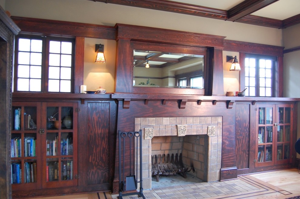 Cette image montre un salon craftsman de taille moyenne et fermé avec une bibliothèque ou un coin lecture, un mur beige, parquet clair et une cheminée standard.