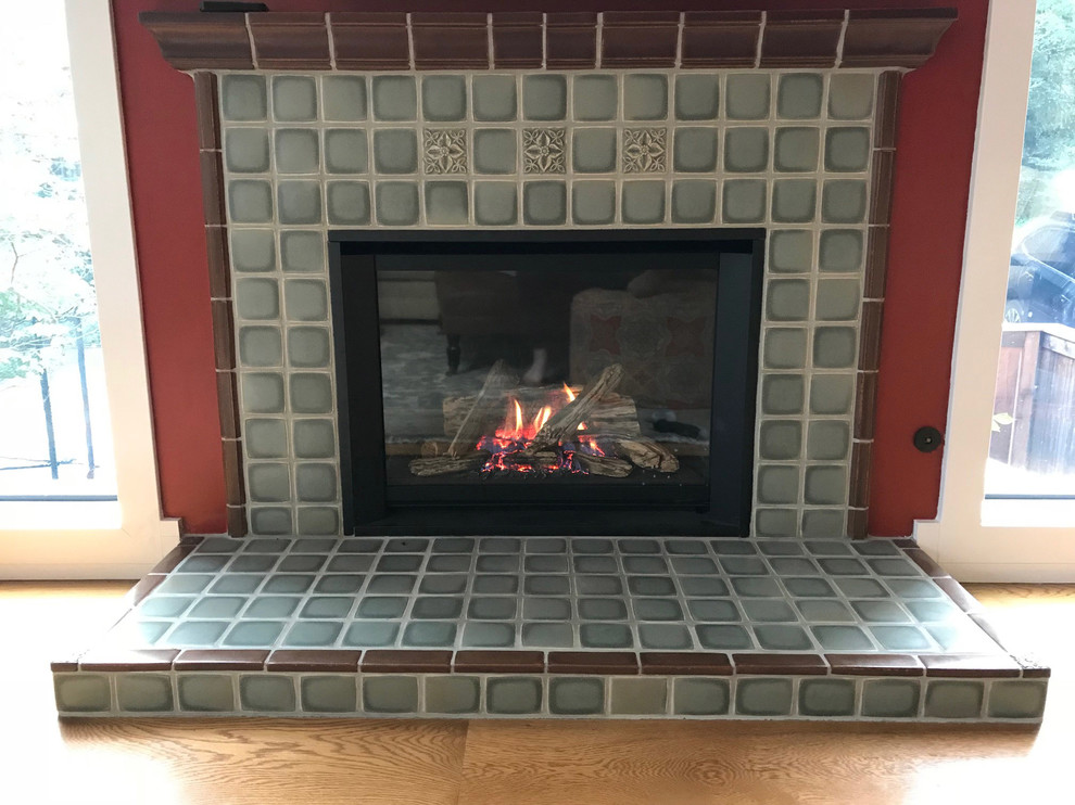 他の地域にあるお手頃価格のトラディショナルスタイルのおしゃれなリビング (赤い壁、淡色無垢フローリング、標準型暖炉、木材の暖炉まわり、茶色い床) の写真